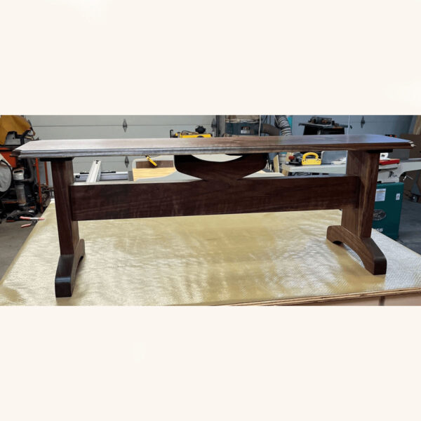 solid dark wood bench on display in a workshop