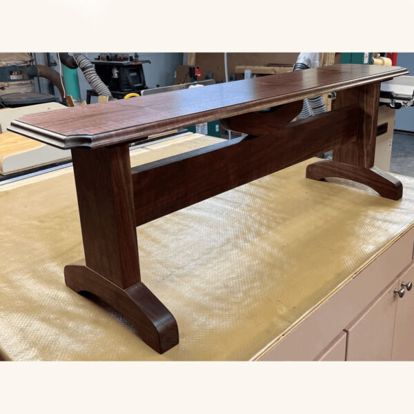 solid dark wood bench on display in a workshop